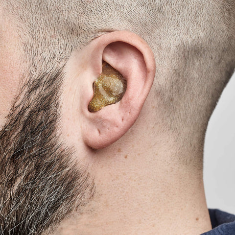 Full shell solid earplugs being worn, side view