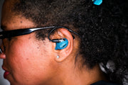 Shure IEM with custom sleeve in turquoise glitter, shown in-ear